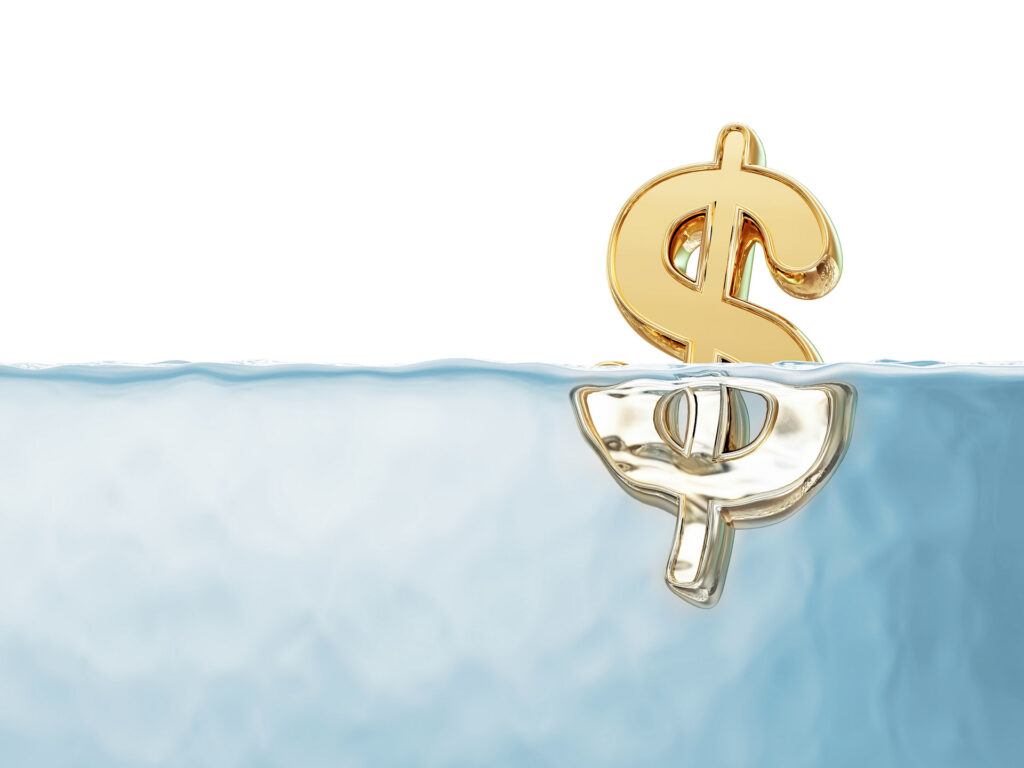 Symbole de dollar doré partiellement immergé dans l’eau.